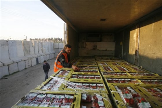 A Palestinian customs worker checks a truck loaded with boxes of strawberries waiting at Kerem Shalom crossing between the Gaza Strip and Israel, on Sunday. Farmers in the Hamas-ruled Gaza Strip began exporting tons of produce to Europe, after Israel cracked open its its volatile border with Gaza for Palestinian goods. A truckload of strawberries left Gaza to launch the season, which is to run through May.